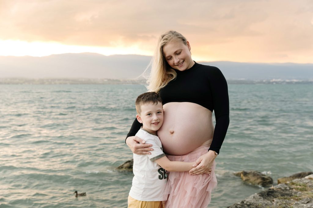  séance photo grossesse au bord du lac Leman avec le coucher de soleil maman avec son fils