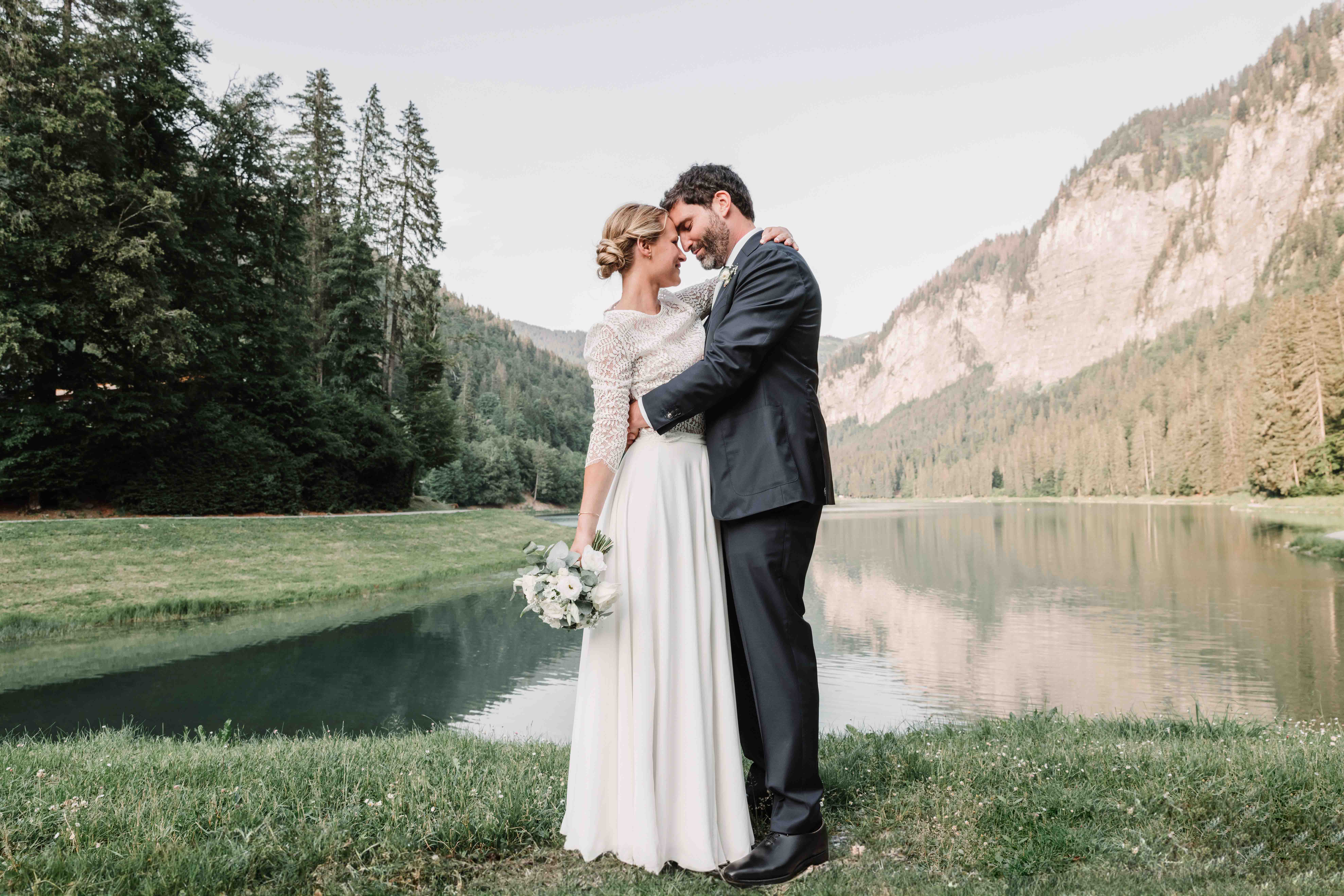 photographie de couple de mariés au lac de Montriond en couleurs avec robe de mariée et bouquet